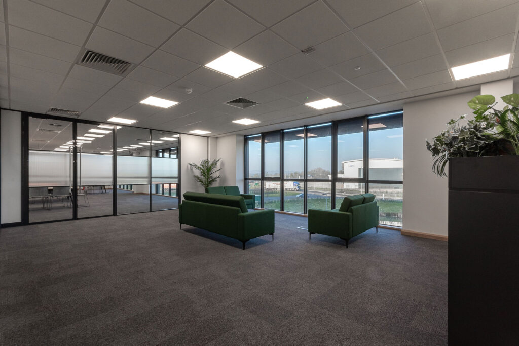 Open area with green upholstered sofas