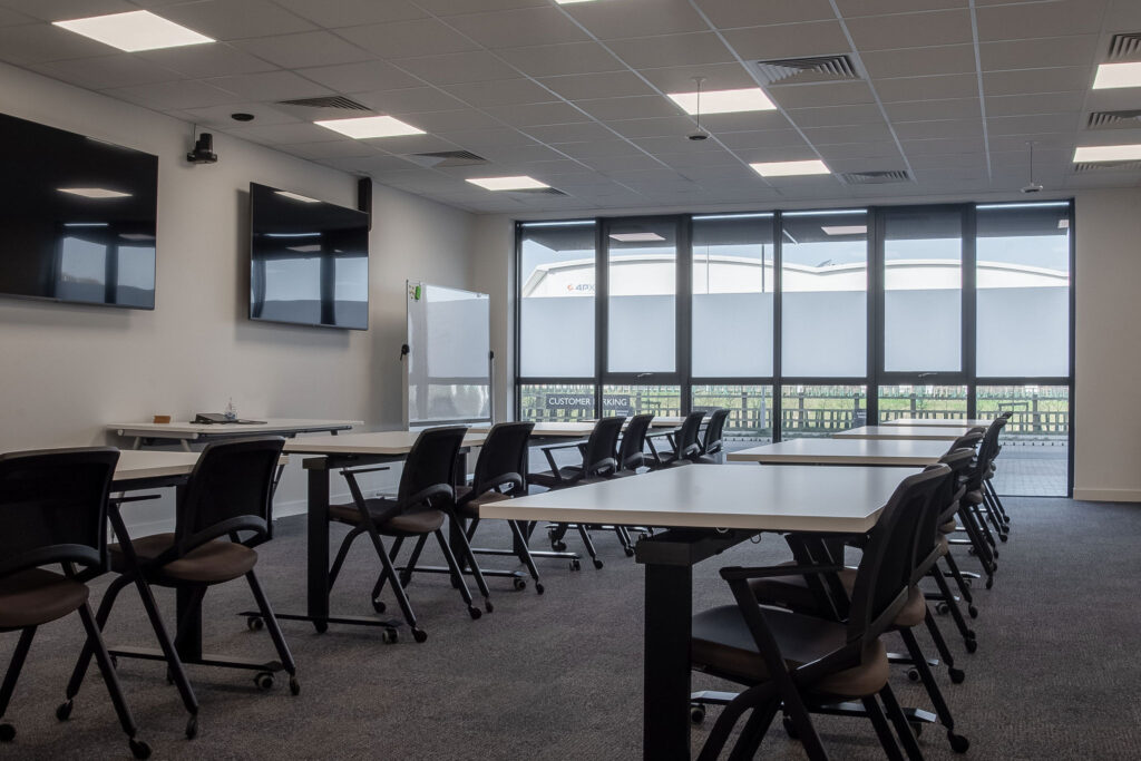 Conference room set out with desks in a row and foldable chairs