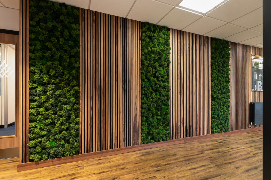 Timber slatted cladding and green moss, forming a feature wall.